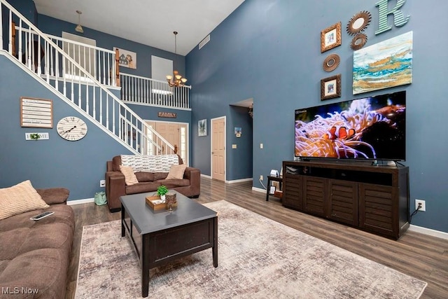 1005 Penn Ct, Grafton, OH 44044 - living area featuring stairway, wood finished floors, a high ceiling, and a chandelier