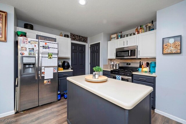 1005 Penn Ct, Grafton, OH 44044 - kitchen featuring stainless steel appliances, white cabinets, wood finished floors, a center island, and light countertops