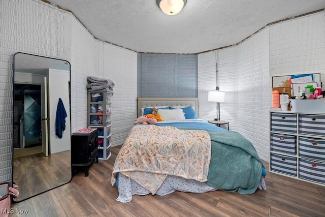 1005 Penn Ct, Grafton, OH 44044 - bedroom featuring a textured ceiling, wood finished floors, and brick wall