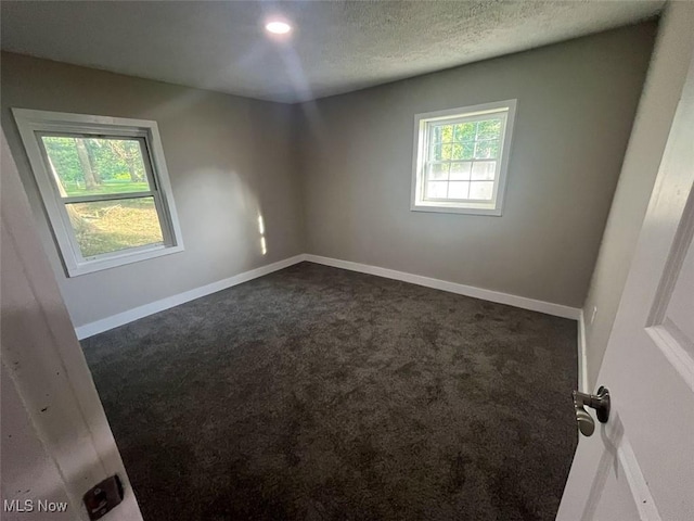 3402 Easton Rd, Norton, OH 44203 - empty room featuring dark colored carpet and a textured ceiling