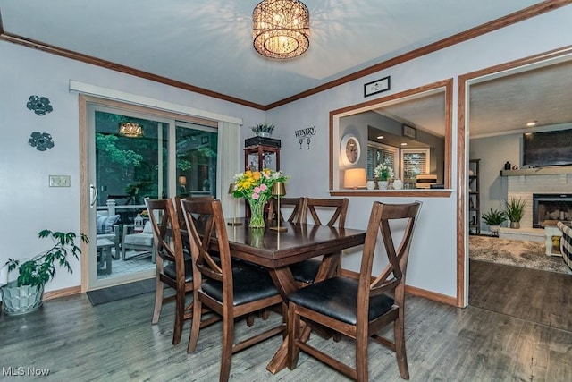 101 Middle Post Pt, Chardon, OH 44024 - dining area featuring wood finished floors, ornamental molding, a brick fireplace, and a chandelier