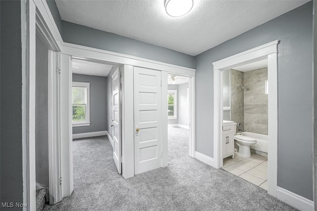 9907 Kempton Ave, Cleveland, OH 44108 - corridor with light colored carpet, a textured ceiling, and light tile patterned floors