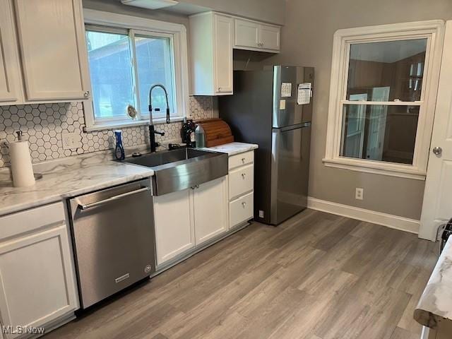 5559 Fitch Rd, North Olmsted, OH 44070 - kitchen featuring stainless steel appliances, white cabinetry, backsplash, and wood finished floors