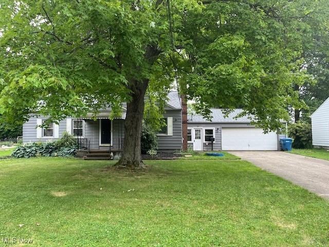 5559 Fitch Rd, North Olmsted, OH 44070 - view of property hidden behind natural elements with a front lawn, driveway, an attached garage, and a chimney