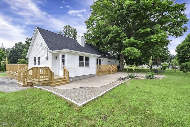 3781 Main St, Perry, OH 44081 - back of property with a shingled roof, a patio area, a chimney, a deck, and a lawn