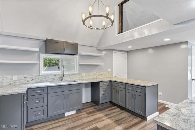 3781 Main St, Perry, OH 44081 - kitchen with open shelves, a peninsula, gray cabinetry, light wood-style floors, and a chandelier