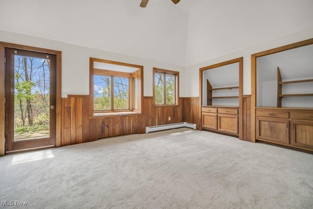 38038 Ridge Rd, Willoughby, OH 44094 - unfurnished living room with a baseboard heating unit, a wainscoted wall, healthy amount of natural light, carpet floors, and a towering ceiling