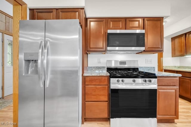 38038 Ridge Rd, Willoughby, OH 44094 - kitchen with appliances with stainless steel finishes, light wood-style floors, light stone countertops, and brown cabinetry