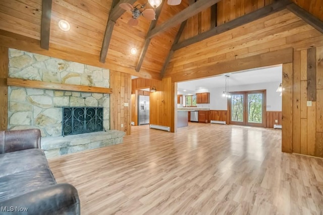 38038 Ridge Rd, Willoughby, OH 44094 - living area featuring a baseboard heating unit, wood walls, light wood finished floors, a stone fireplace, and high vaulted ceiling