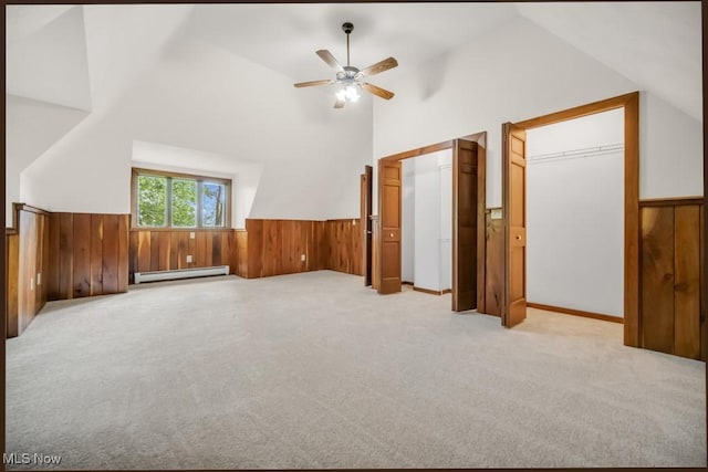 38038 Ridge Rd, Willoughby, OH 44094 - unfurnished bedroom featuring baseboard heating, lofted ceiling, a wainscoted wall, light colored carpet, and wooden walls