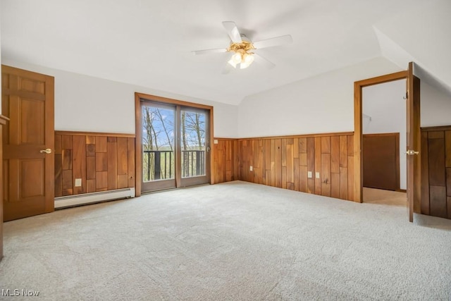 38038 Ridge Rd, Willoughby, OH 44094 - carpeted empty room featuring a baseboard radiator, wainscoting, vaulted ceiling, a ceiling fan, and wooden walls