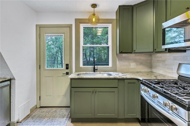 2269 N Fox N Rd, Hubbard, OH 44425 - kitchen with green cabinetry, stainless steel appliances, light stone countertops, decorative backsplash, and decorative light fixtures