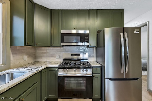 2269 N Fox N Rd, Hubbard, OH 44425 - kitchen featuring green cabinets, stainless steel appliances, tasteful backsplash, and a textured ceiling
