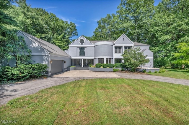 6869 Cliffside Dr, Vermilion, OH 44089 - view of front facade with asphalt driveway, a front yard, stucco siding, and a garage