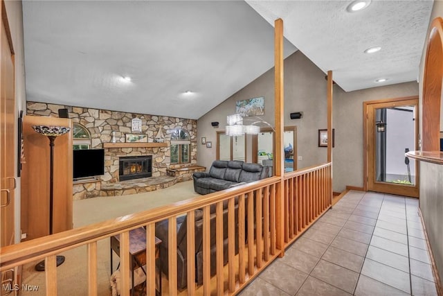 6869 Cliffside Dr, Vermilion, OH 44089 - living room with light tile patterned floors, a stone fireplace, a textured ceiling, lofted ceiling, and recessed lighting
