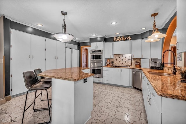 6869 Cliffside Dr, Vermilion, OH 44089 - kitchen with stainless steel appliances, white cabinetry, dark stone counters, crown molding, and backsplash