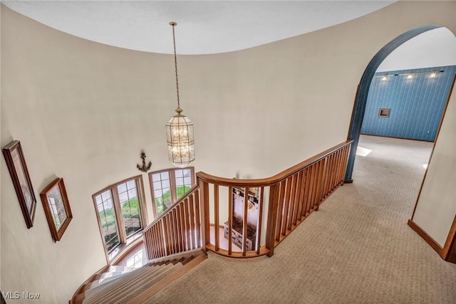 6869 Cliffside Dr, Vermilion, OH 44089 - stairs with carpet flooring, a chandelier, arched walkways, and a towering ceiling
