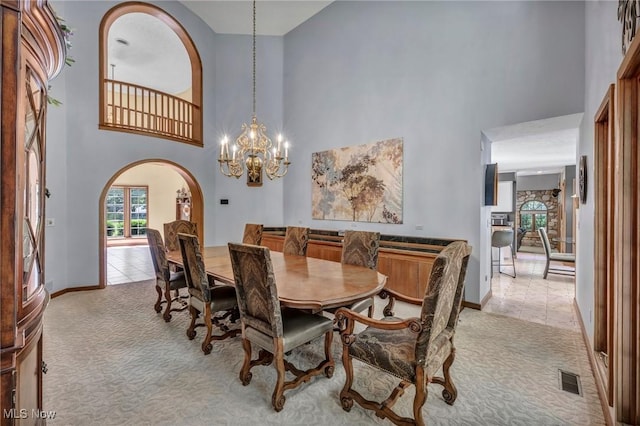 6869 Cliffside Dr, Vermilion, OH 44089 - dining room with a high ceiling, arched walkways, light colored carpet, and a chandelier