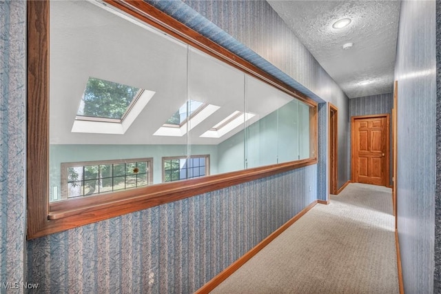 6869 Cliffside Dr, Vermilion, OH 44089 - hallway with carpet floors, a skylight, wallpapered walls, and a textured ceiling