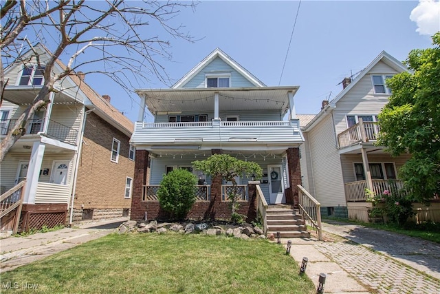 1289 W 115th St, Cleveland, OH 44102 - view of front of house with a balcony, a porch, brick siding, and a front lawn