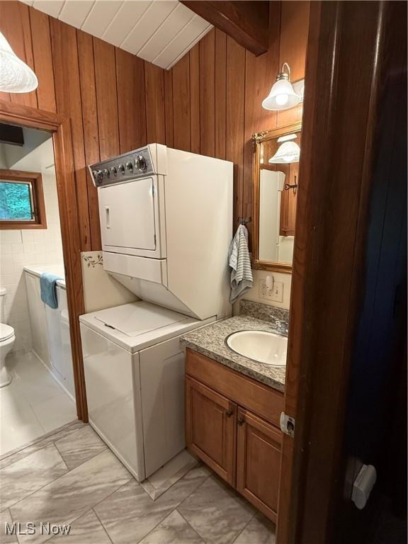 126 Stony Creek Dr, Millersburg, OH 44654 - bathroom featuring estacked washer and dryer, wooden walls, vanity, wood ceiling, and lofted ceiling