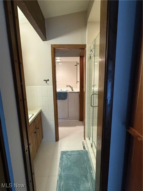 126 Stony Creek Dr, Millersburg, OH 44654 - full bath with vanity, a shower stall, tile walls, tile patterned flooring, and a wainscoted wall