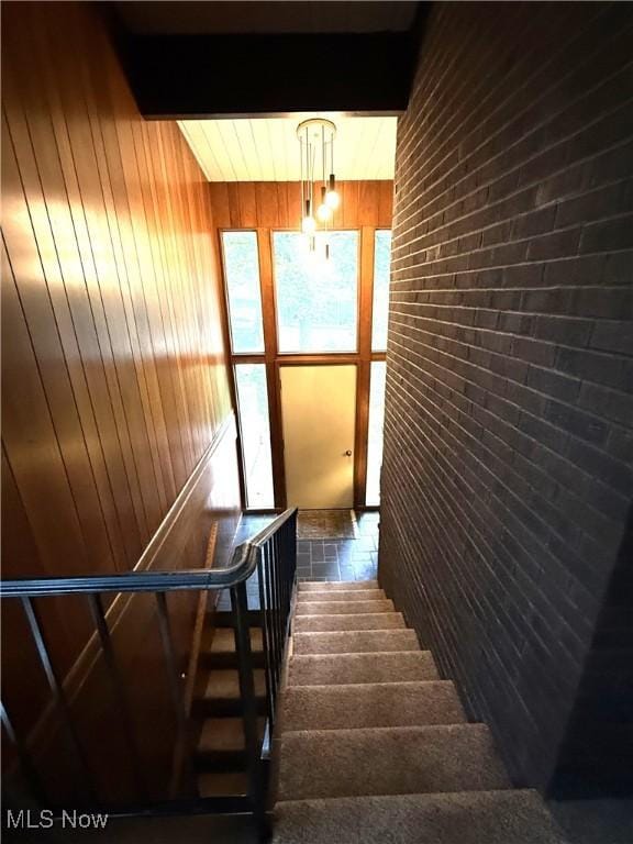 126 Stony Creek Dr, Millersburg, OH 44654 - stairs with wood walls, brick wall, and beam ceiling