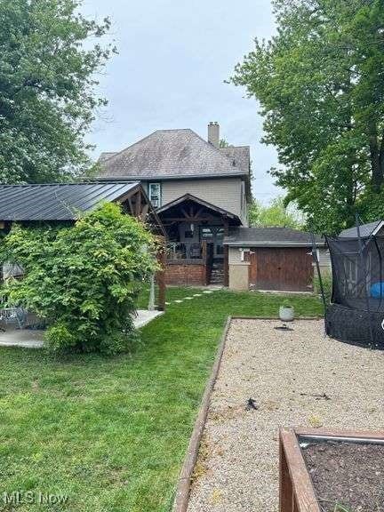 202 N Ray St, Baltic, OH 43804 - rear view of property with a lawn, a garden, and a chimney