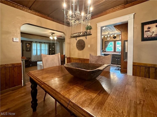 220 N Cleveland Ave, Niles, OH 44446 - dining space with arched walkways, a wainscoted wall, wood finished floors, a chandelier, and wooden walls