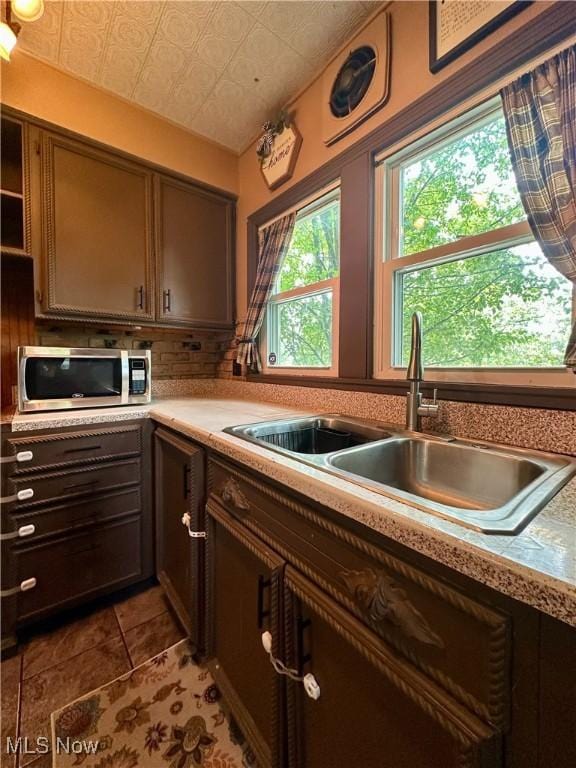 220 N Cleveland Ave, Niles, OH 44446 - kitchen featuring stainless steel microwave, an ornate ceiling, light countertops, tasteful backsplash, and light tile patterned floors