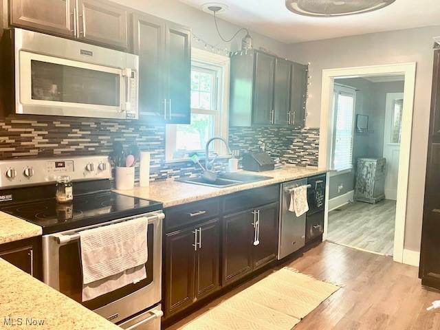 127 William St, Struthers, OH 44471 - kitchen with stainless steel appliances, light wood-style floors, and backsplash