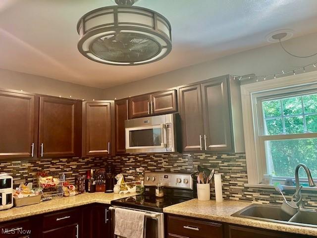 127 William St, Struthers, OH 44471 - kitchen featuring appliances with stainless steel finishes, backsplash, and dark brown cabinets