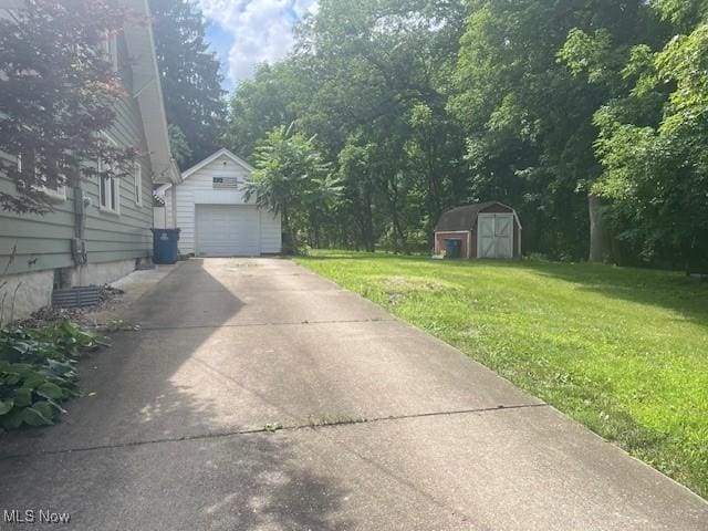 127 William St, Struthers, OH 44471 - view of grassy yard featuring a garage, driveway, and a shed