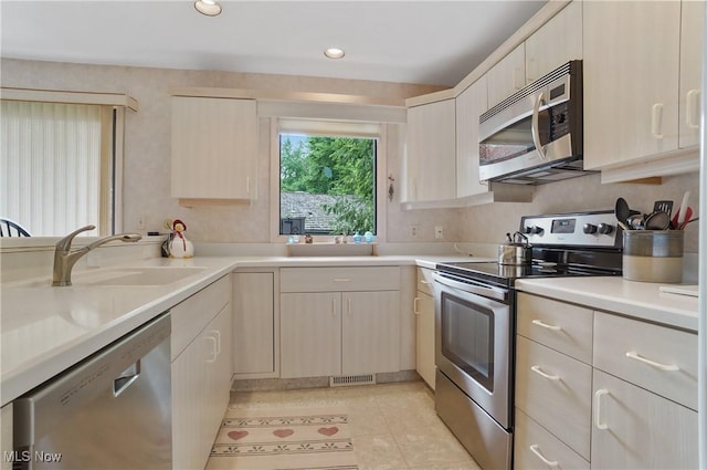 680-7 Windward Dr, Aurora, OH 44202 - kitchen with appliances with stainless steel finishes, light countertops, light brown cabinetry, light tile patterned floors, and recessed lighting