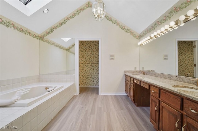 3773 N Shore Dr, Akron, OH 44333 - full bathroom with a skylight, lofted ceiling, double vanity, a bath, and wood finished floors