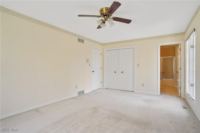 3773 N Shore Dr, Akron, OH 44333 - unfurnished bedroom featuring light carpet, connected bathroom, ceiling fan, and a closet