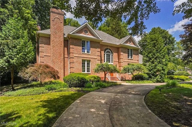 3773 N Shore Dr, Akron, OH 44333 - georgian-style home featuring a chimney and brick siding