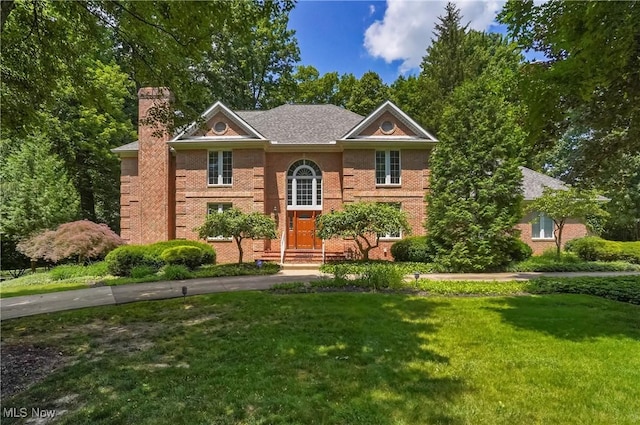 3773 N Shore Dr, Akron, OH 44333 - view of front of home with a front lawn, a chimney, and brick siding