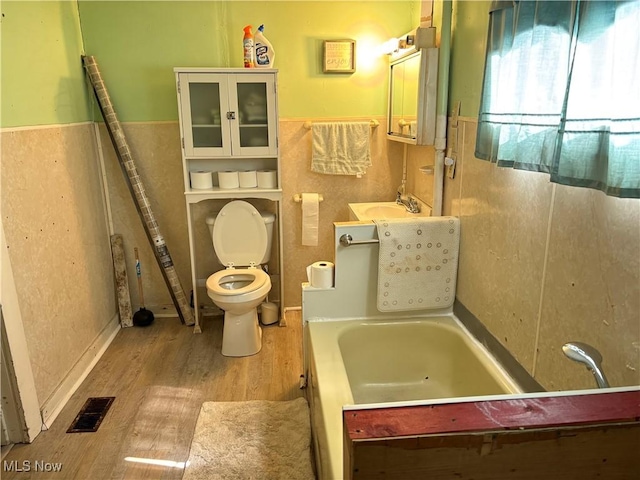 1209 Camden Ave, Parkersburg, WV 26101 - bathroom with wood finished floors, a tub to relax in, a wainscoted wall, and vanity