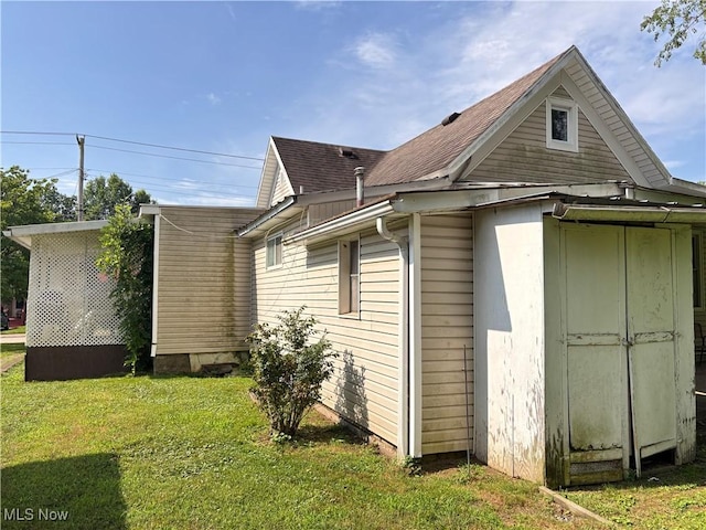1209 Camden Ave, Parkersburg, WV 26101 - view of side of property featuring a lawn and roof with shingles