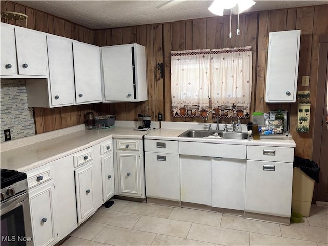 1209 Camden Ave, Parkersburg, WV 26101 - kitchen with white cabinetry, light countertops, wood walls, stainless steel electric range oven, and light tile patterned floors