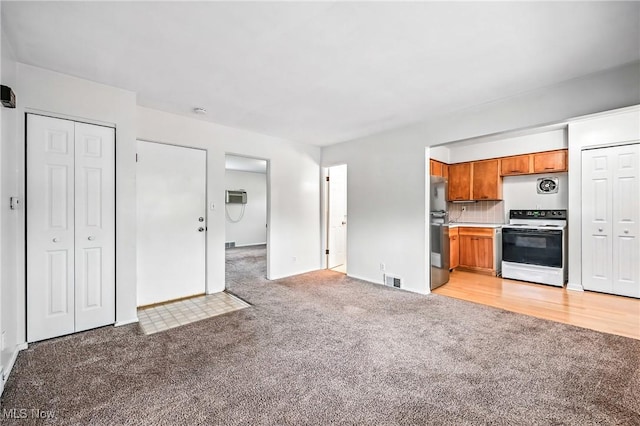 16-18 E Linwood Ave, Akron, OH 44301 - kitchen with white electric range, light carpet, fridge, and brown cabinets