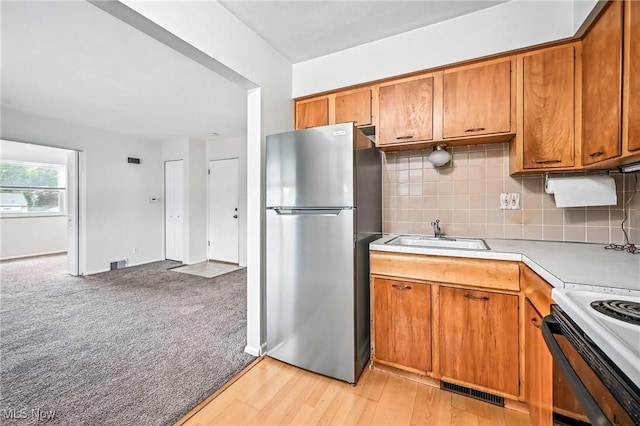 16-18 E Linwood Ave, Akron, OH 44301 - kitchen with freestanding refrigerator, light countertops, brown cabinets, and decorative backsplash
