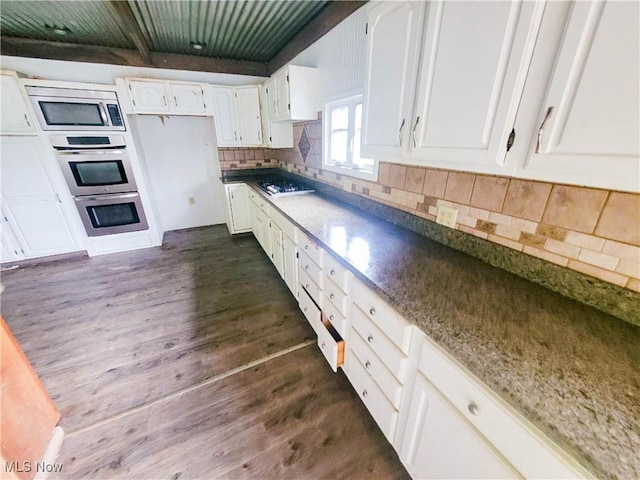 56612 Mcgee Rd, Shadyside, OH 43947 - kitchen featuring stainless steel microwave, white cabinets, gas cooktop, dark wood finished floors, and a wooden ceiling with exposed beams