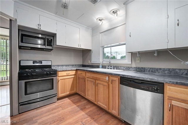 4465 Oberlin Ave, Lorain, OH 44053 - kitchen with stainless steel appliances, light wood-style flooring, dark countertops, and white cabinetry