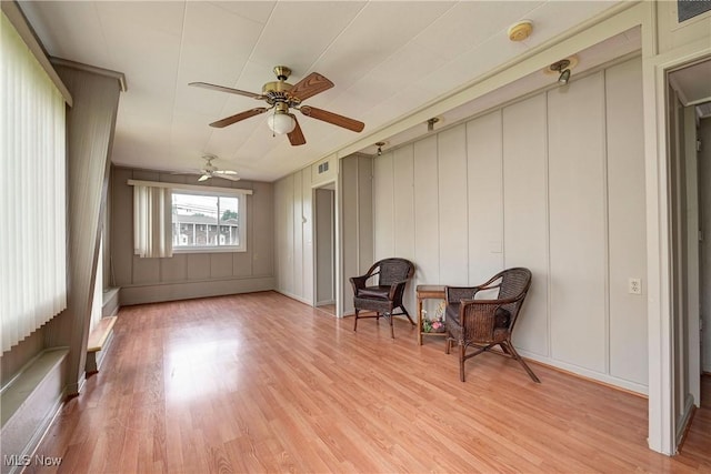 4465 Oberlin Ave, Lorain, OH 44053 - living area with light wood-type flooring, ceiling fan, and a decorative wall