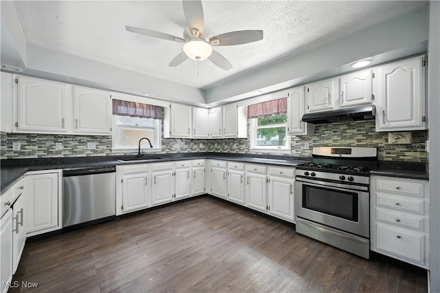 77 W Park Ave, Hubbard, OH 44425 - kitchen with stainless steel appliances, under cabinet range hood, dark countertops, white cabinets, and a textured ceiling