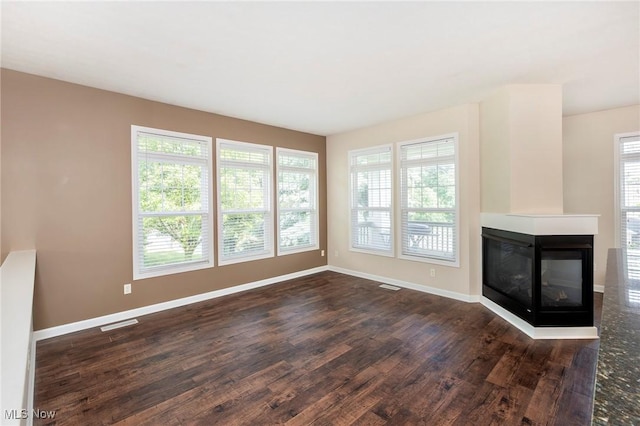 101 Stonegate Cir, Seven Hills, OH 44131 - unfurnished living room featuring dark wood finished floors and a multi sided fireplace