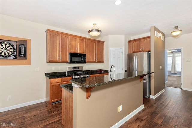 101 Stonegate Cir, Seven Hills, OH 44131 - kitchen with appliances with stainless steel finishes, dark wood-style flooring, dark stone countertops, an island with sink, and a breakfast bar area