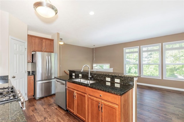 101 Stonegate Cir, Seven Hills, OH 44131 - kitchen with appliances with stainless steel finishes, dark wood-type flooring, dark stone counters, an island with sink, and brown cabinets